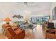 Comfortable living room featuring wood floors, neutral walls, and a screened-in lanai at 340 Juniper Way, Tavares, FL 32778
