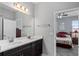 Bathroom featuring a dual sink vanity and a glimpse of the bedroom at 37045 Scenic Ridge Dr, Grand Island, FL 32735