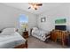 Bright bedroom featuring twin beds, neutral walls, and a ceiling fan for comfortable living at 37045 Scenic Ridge Dr, Grand Island, FL 32735