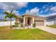 Inviting single-story home with a neatly kept lawn, palm tree, and welcoming front porch at 37045 Scenic Ridge Dr, Grand Island, FL 32735