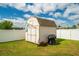 Exterior shed with white painted wood, a charcoal grill nearby and a sunny sky above at 37045 Scenic Ridge Dr, Grand Island, FL 32735
