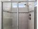 Close up of the shower with decorative tile and a rainfall shower head at 37045 Scenic Ridge Dr, Grand Island, FL 32735
