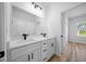 Bathroom boasts double vanity, white cabinets, matte black hardware, and view to bedroom at 3978 Sw 151St St, Ocala, FL 34473