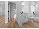 Bathroom featuring white cabinets with black hardware, dual vanity, toilet and tub at 3978 Sw 151St St, Ocala, FL 34473