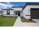 Beautiful home exterior featuring a well-kept lawn and modern black and white accents on the facade at 3978 Sw 151St St, Ocala, FL 34473