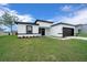 Inviting home exterior featuring manicured lawn and modern black and white accents on the facade at 3978 Sw 151St St, Ocala, FL 34473