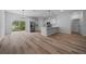 Open-concept kitchen with island and stainless steel appliances, adjoining a spacious, bright living area with modern flooring at 3978 Sw 151St St, Ocala, FL 34473