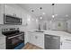 Bright kitchen featuring white cabinets, stainless steel appliances, quartz countertops, and undermount sink with pendant lighting at 3978 Sw 151St St, Ocala, FL 34473