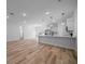Open-concept living space with modern hardwood floors flowing into a bright kitchen area with white countertops at 3978 Sw 151St St, Ocala, FL 34473