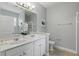 Bright bathroom featuring double sinks, white cabinetry, and a framed mirror at 4147 Oaktree Dr, Davenport, FL 33837