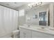 Clean bathroom with dual sinks, a large mirror, and plenty of counter space at 4147 Oaktree Dr, Davenport, FL 33837