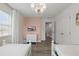 Bright bedroom with twin beds, modern pink accent wall, and a decorative chandelier at 4147 Oaktree Dr, Davenport, FL 33837