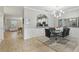 Stylish dining room with elegant light fixture, glass table, and view into living room at 4147 Oaktree Dr, Davenport, FL 33837