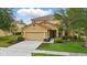 Charming two-story home with manicured lawn, beautiful landscaping, and neutral color palette at 4147 Oaktree Dr, Davenport, FL 33837