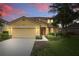 Two-story home with neutral color palette and well-manicured front lawn at 4147 Oaktree Dr, Davenport, FL 33837