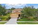 Charming two-story home with a well-manicured front lawn, landscaping, and attached garage at 4147 Oaktree Dr, Davenport, FL 33837