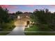 Two-story home featuring lovely landscaping, paired with a twilight sky at 4147 Oaktree Dr, Davenport, FL 33837
