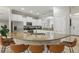 Bright kitchen with white cabinets, stainless steel appliances, granite countertops, and a breakfast bar with four chairs at 4147 Oaktree Dr, Davenport, FL 33837