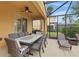 Covered outdoor dining area with a large table, chairs, ceiling fan, and grilling area at 4147 Oaktree Dr, Davenport, FL 33837