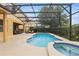 Screened-in pool and spa with ample patio space for entertaining and relaxing at 4147 Oaktree Dr, Davenport, FL 33837