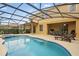 A screened-in pool and spa, plus a covered patio with an outdoor kitchen and dining area at 4147 Oaktree Dr, Davenport, FL 33837