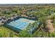 Birds eye view of tennis courts in a neighborhood with lush landscaping and mature trees at 4147 Oaktree Dr, Davenport, FL 33837