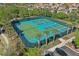 Aerial view of tennis courts with palm trees in a meticulously maintained, gated community at 4147 Oaktree Dr, Davenport, FL 33837