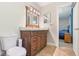Bathroom featuring a wood vanity, a mirror, a toilet, and a doorway to a bedroom at 42116 E Lakeview Dr, Altoona, FL 32702