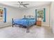 Bedroom featuring two windows, fan and metal frame bed with blue coverlet at 42116 E Lakeview Dr, Altoona, FL 32702