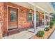 Inviting front porch with brick facade, rocking chairs, and tasteful landscaping at 42116 E Lakeview Dr, Altoona, FL 32702