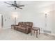 Cozy living room featuring tile flooring, a ceiling fan, and a comfortable brown leather sofa at 42116 E Lakeview Dr, Altoona, FL 32702