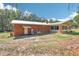 Rear exterior of the home showcasing brick, metal roof, and screened-in porch at 42116 E Lakeview Dr, Altoona, FL 32702