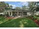 Charming backyard featuring lush green grass, landscaped flower beds, and an enclosed porch at 4349 River Ridge Dr, Leesburg, FL 34748
