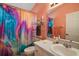 Bright bathroom with a colorful shower curtain, white sink vanity, and mirrored wall cabinet at 4349 River Ridge Dr, Leesburg, FL 34748