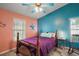 Charming bedroom featuring blue and salmon-colored walls, a wooden bed frame, and a ceiling fan at 4349 River Ridge Dr, Leesburg, FL 34748