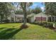 Inviting single-story home featuring mature trees, lush green lawn, and a decorative driveway and a two-car garage at 4349 River Ridge Dr, Leesburg, FL 34748