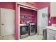 Well-organized laundry room with modern washer and dryer, wire shelving, and a white door at 4349 River Ridge Dr, Leesburg, FL 34748