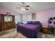 Spacious main bedroom featuring a purple bed, a dresser, neutral walls, and a ceiling fan at 4349 River Ridge Dr, Leesburg, FL 34748