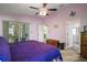 Large primary bedroom with ceiling fan, a walk out to the screened porch, and ensuite bathroom at 4349 River Ridge Dr, Leesburg, FL 34748