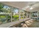 Enclosed patio with tile flooring, ceiling fan, and scenic views of the landscaped backyard at 4349 River Ridge Dr, Leesburg, FL 34748