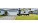Charming home featuring well-manicured lawn, brick driveway, and eye-catching stacked stone accents at 496 Brunswick Dr, Davenport, FL 33837
