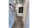 Well-lit hallway with wood-look tile flooring, stylish artwork, and convenient closet access, creating a seamless flow at 496 Brunswick Dr, Davenport, FL 33837