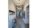 Stylish hallway with wood-look tile flooring, modern light fixture, and vibrant artwork, showcasing a chic design at 496 Brunswick Dr, Davenport, FL 33837