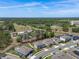Wide aerial shot of a residential area near wooded areas and a power station in a sunny, clear-sky day at 524 Avila Pl, Howey In The Hills, FL 34737