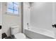 Bright bathroom with a combined tub and shower and a window above the toilet at 524 Avila Pl, Howey In The Hills, FL 34737