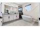 Bright bathroom with double sink vanity, large mirror, and freestanding soaking tub under a window at 524 Avila Pl, Howey In The Hills, FL 34737