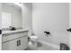 Modern bathroom featuring a granite countertop, white vanity, toilet, and sleek black hardware at 524 Avila Pl, Howey In The Hills, FL 34737