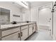 Well-lit bathroom with double sinks, granite countertops, white cabinets, and a shower at 524 Avila Pl, Howey In The Hills, FL 34737
