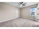 Bright bedroom with carpet, neutral walls, ceiling fan, and a window with neighborhood views at 524 Avila Pl, Howey In The Hills, FL 34737