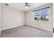 Carpeted bedroom with a large window, providing natural light and views of the neighborhood at 524 Avila Pl, Howey In The Hills, FL 34737